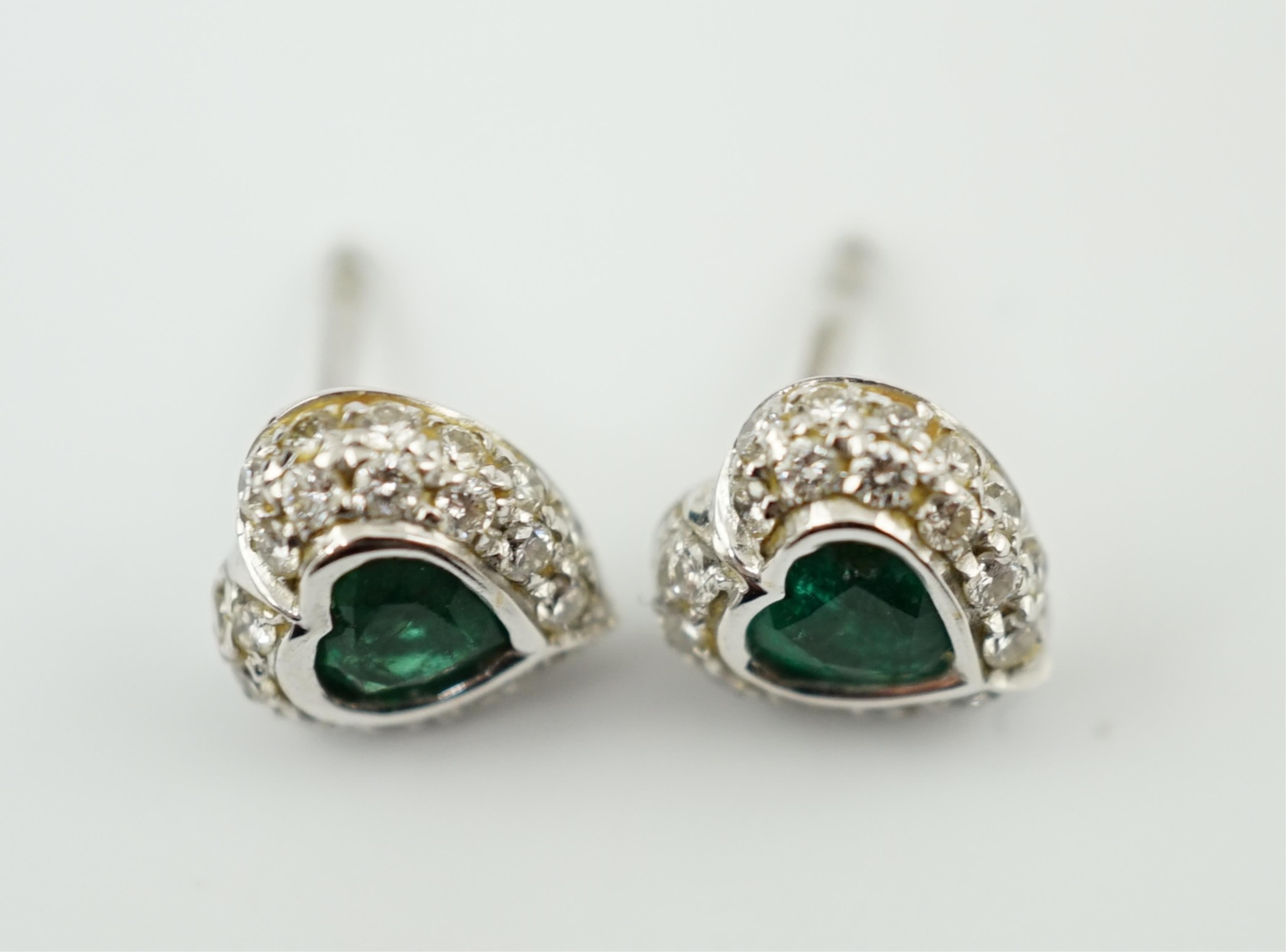 A modern pair of 18ct white gold, emerald and diamond set heart shaped cluster ear studs